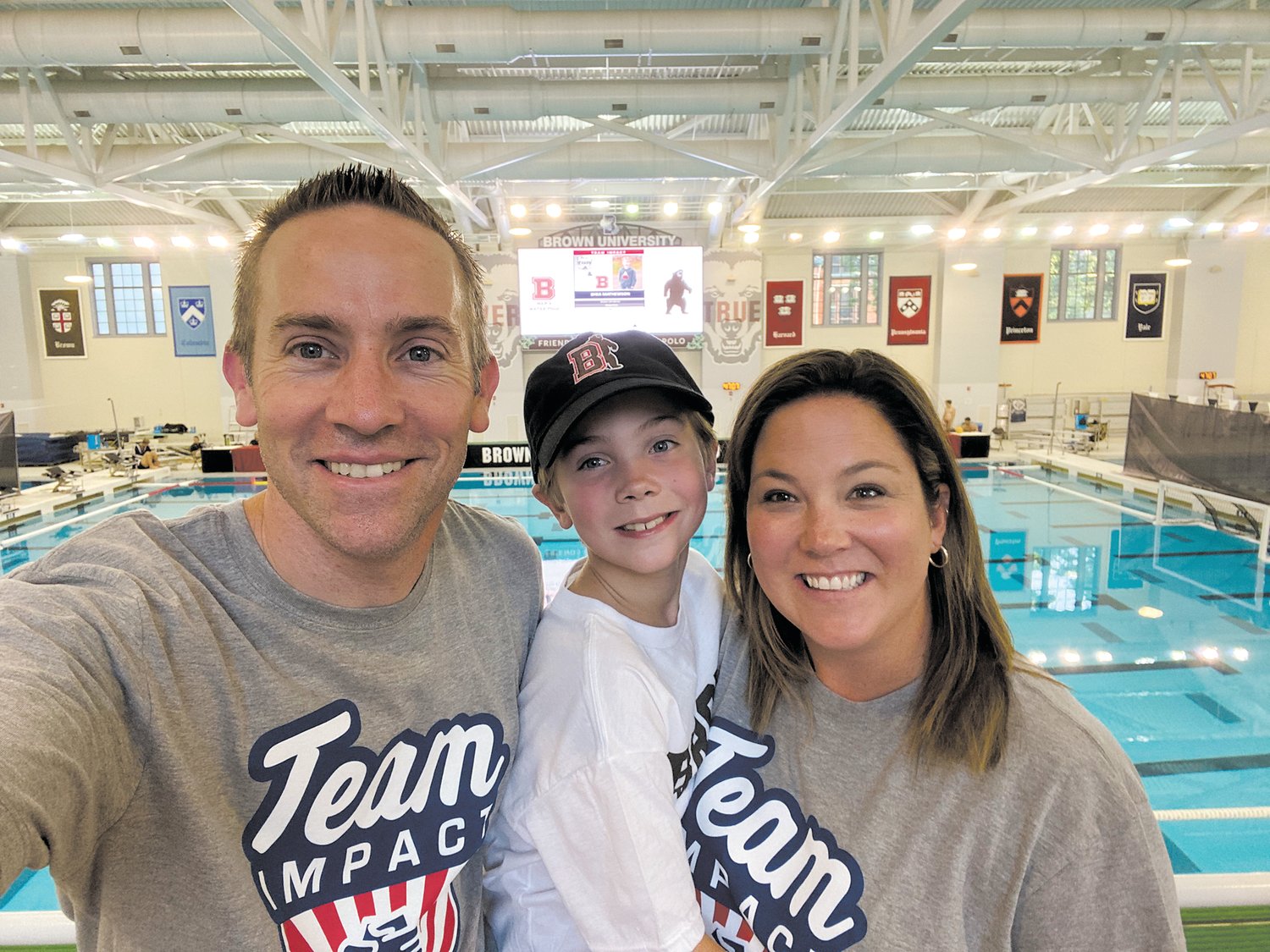 A NEW TEAMMATE: Shea Mathewson with his parents, Jimmy and Jesse, at Brown University in their Team IMPACT shirts. Team IMPACT is a national non-profit organization that matches children facing serious illness and disability with college athletic teams across the country. Shea is a new member of the Men’s Water Polo team.